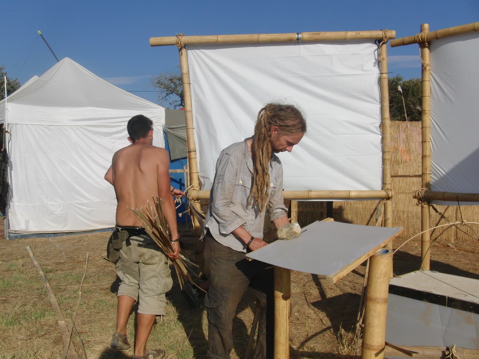 Assembling the screen frame beside a tent, Boom 2010