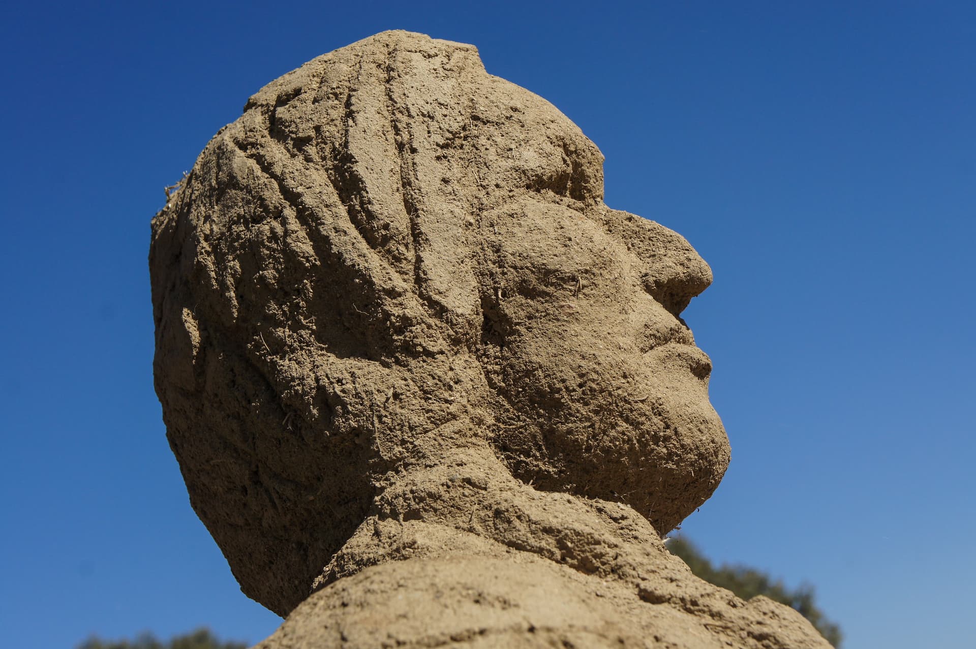 Rammed earth head sculpture against the sky, Boom 2012