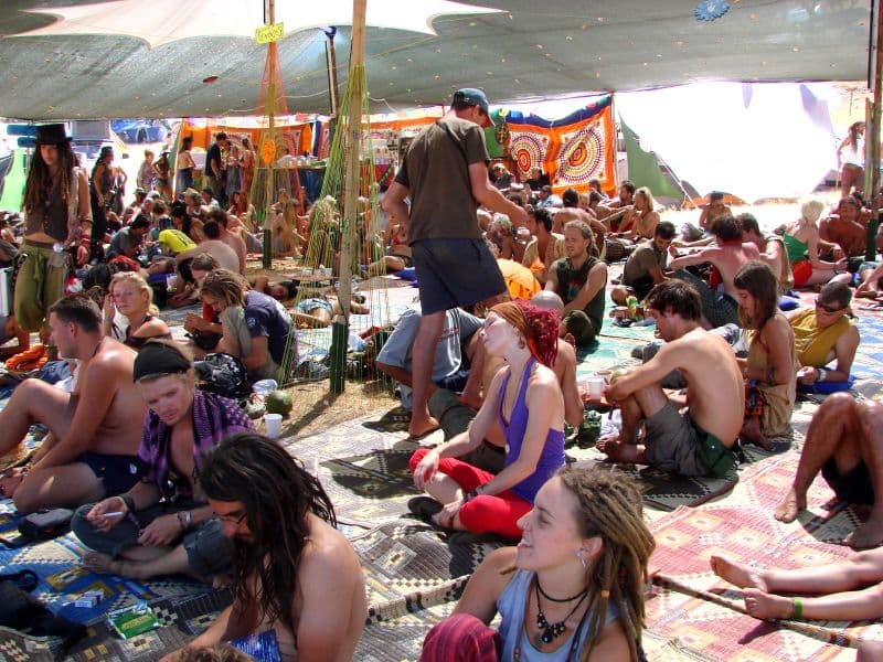 Crowd resting under a shaded market tent