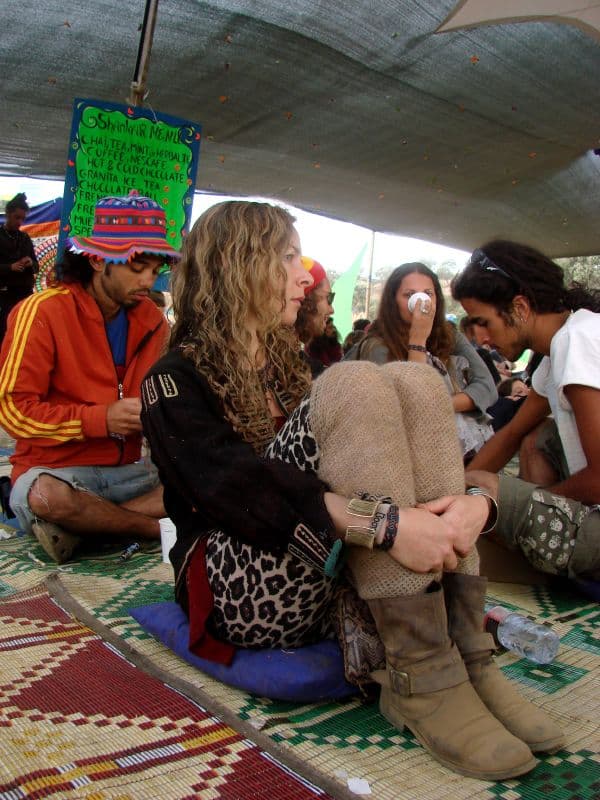 Group seated on rugs in a shaded lounge
