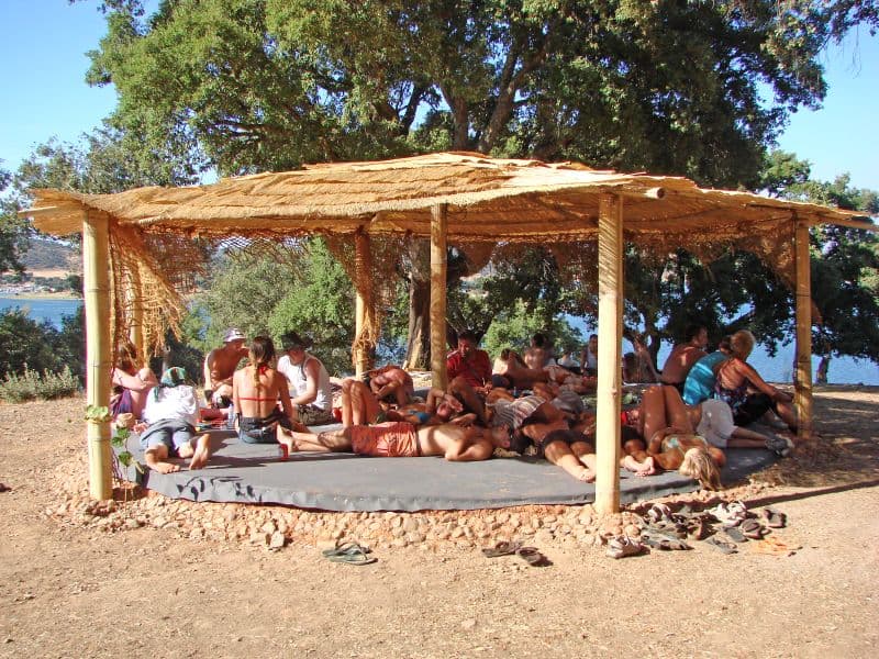 Reed-roofed shelter with people seated inside