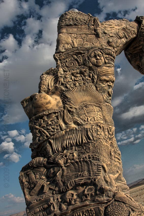 Carved Totem Pillar with Faces and Symbols