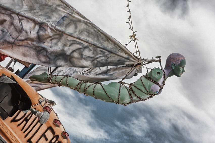 Green mermaid mannequin rigged on an art-car mast