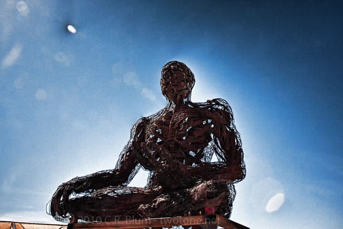 Woven Meditating Figure Against the Sky