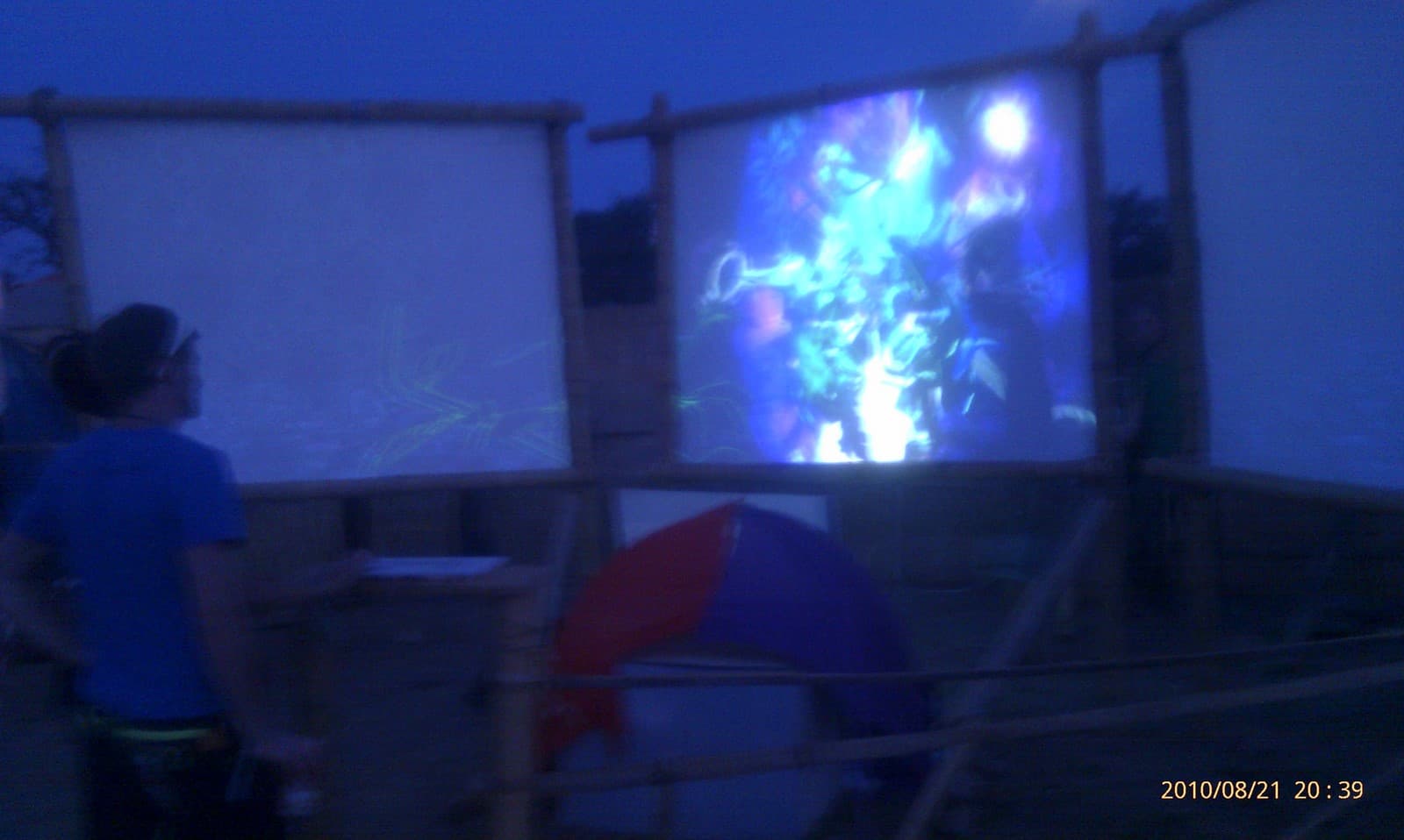 Projection screen glowing beside the camp at night, Boom 2010