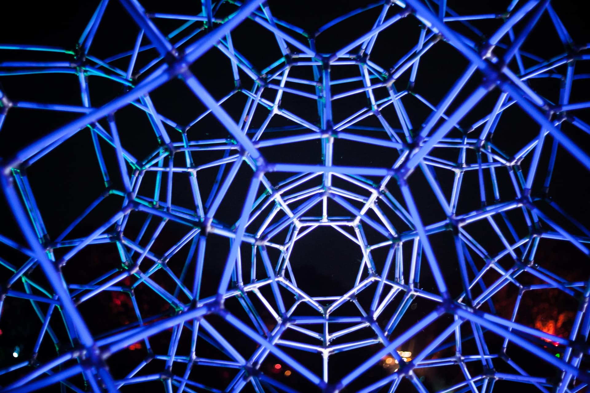 Geodesic dome lit in blue at night