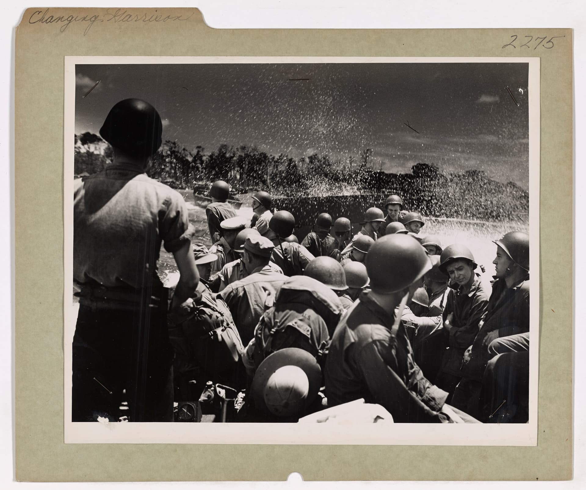 From a Coast Guard-manned assault transport, a party of soldiers arrives on the beaches of New Britain to replace a contingent of Marines being moved aboard the Coast Guard-manned ship to Russell isla