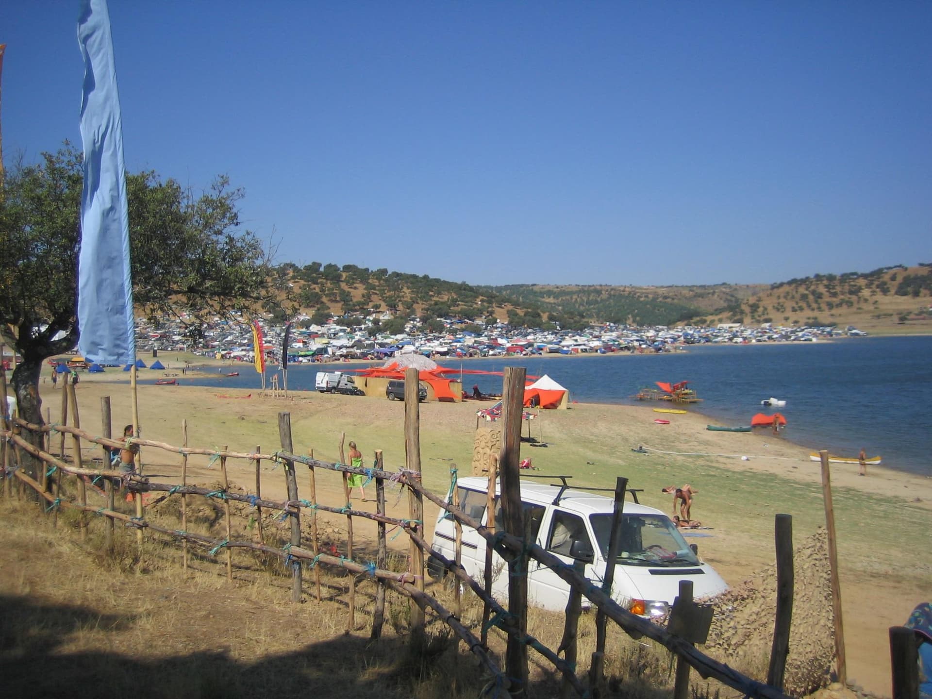 Camp and shoreline seen across the fence